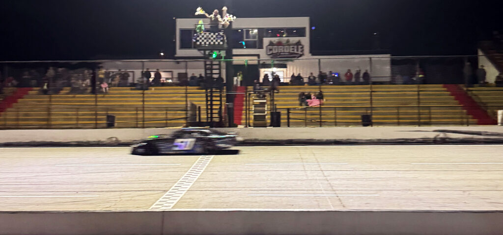 Jett Noland #50 crosses the finish line in first place at Cordele Motor Speedway, securing a victory under the checkered flag.